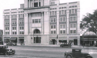 Historic street view of a large Masonic Temple building with arched entrance and decorative facade, early 20th-century cars parked along the curb.