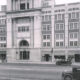 Historic street view of a large Masonic Temple building with arched entrance and decorative facade, early 20th-century cars parked along the curb.
