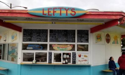 Colorful roadside food stand named Lefty's with chalk-menu boards above the windows and a turquoise-blue base.