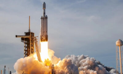 SpaceX rocket lifting off from a launch pad with bright flames and a plume of smoke rising around the rocket.