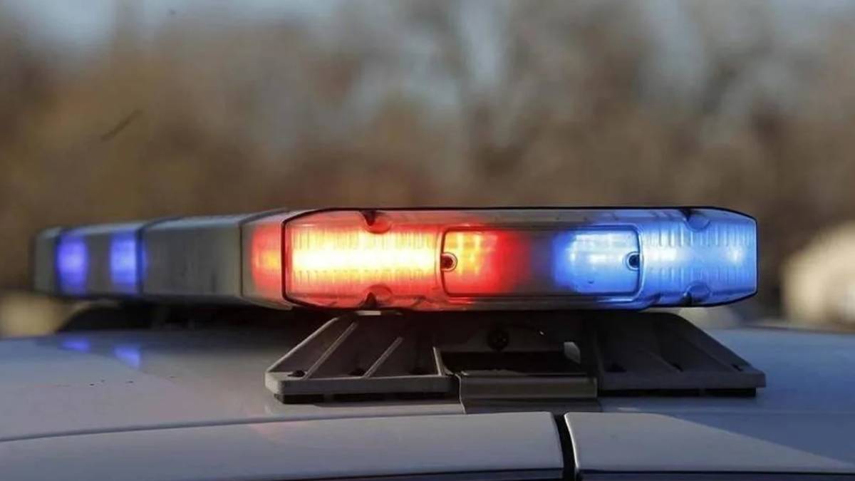 Police car roof light flashing red and blue, signaling an emergency.