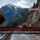 Mountain highway construction scene with a yellow CAT excavator on a rocky slope, warning sign, guardrail, and a banner announcing the North Cascades Highway opened early in red text.