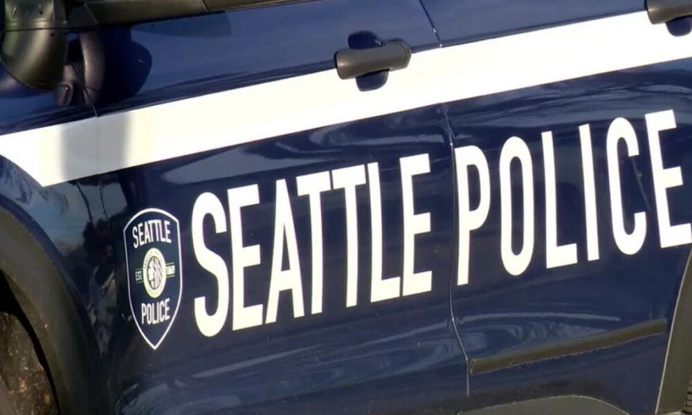 Side view of a Seattle Police Department patrol car with large 'SEATTLE POLICE' lettering and badge logo on the door