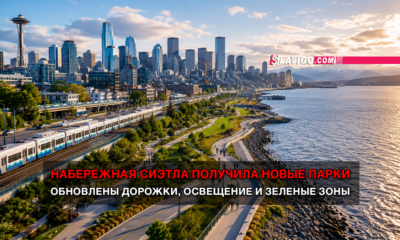 Seattle skyline and waterfront park with a tram along the tracks; red Russian headline about Seattle’s waterfront getting new parks and updated paths and lighting (Slavigo)