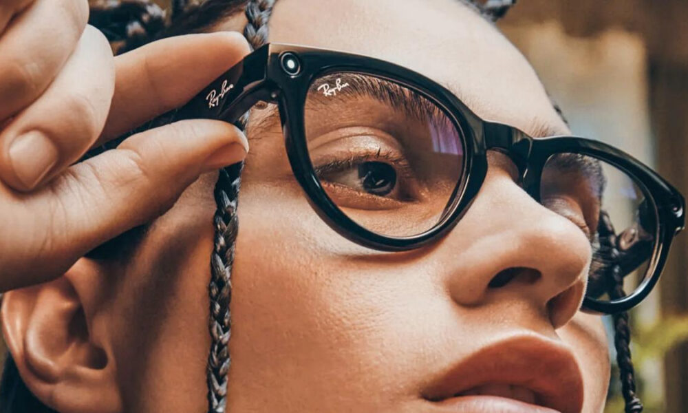 Close-up of a person wearing black Ray‑Ban glasses, adjusting a braided strap near the frame.