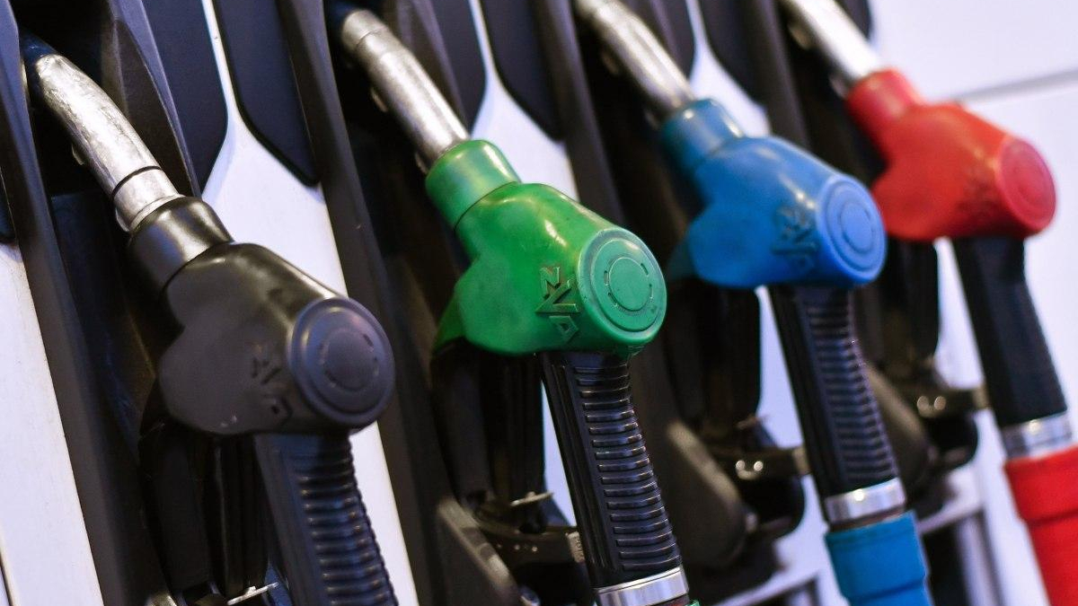 Row of fuel nozzles at a gas pump in black, green, blue, and red colors without focusing on any single one