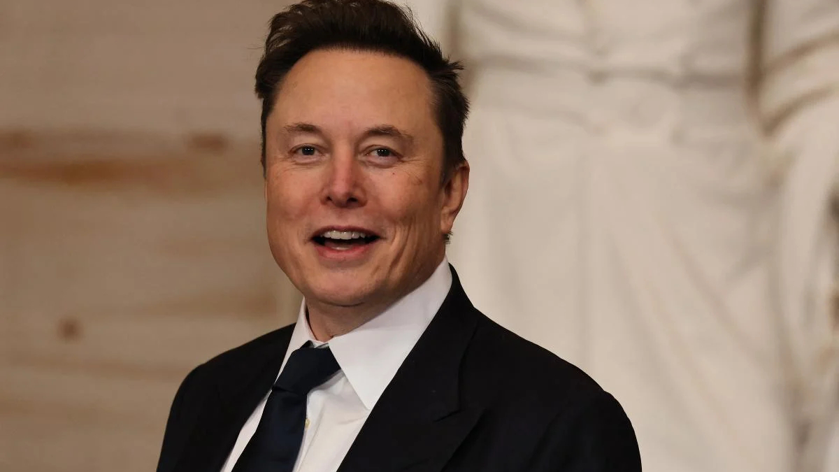 Smiling man in a black suit and white shirt at a formal event, looking at the camera in a portrait shot.