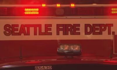 Seattle Fire Department vehicle with flashing red emergency lights at night/scene boundary.