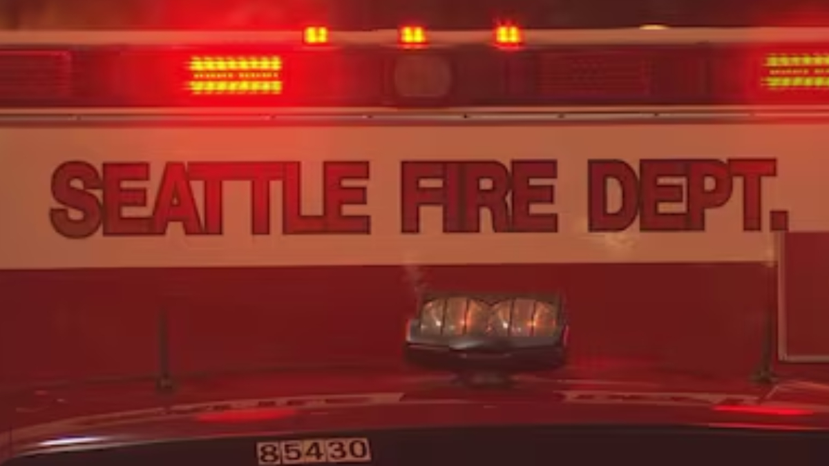Seattle Fire Department vehicle with flashing red emergency lights at night/scene boundary.