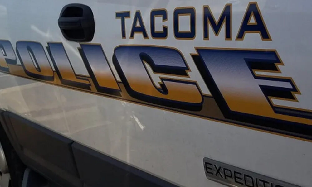 Side of a Tacoma police van with large 'POLICE' lettering and 'Tacoma' above it on the body panel.