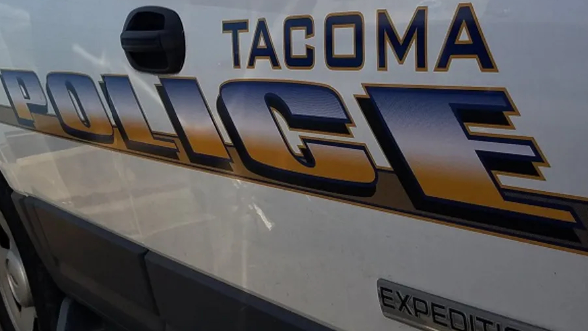 Side of a Tacoma police van with large 'POLICE' lettering and 'Tacoma' above it on the body panel.