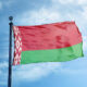 Belarus flag waving on a flagpole against a blue sky with white clouds.