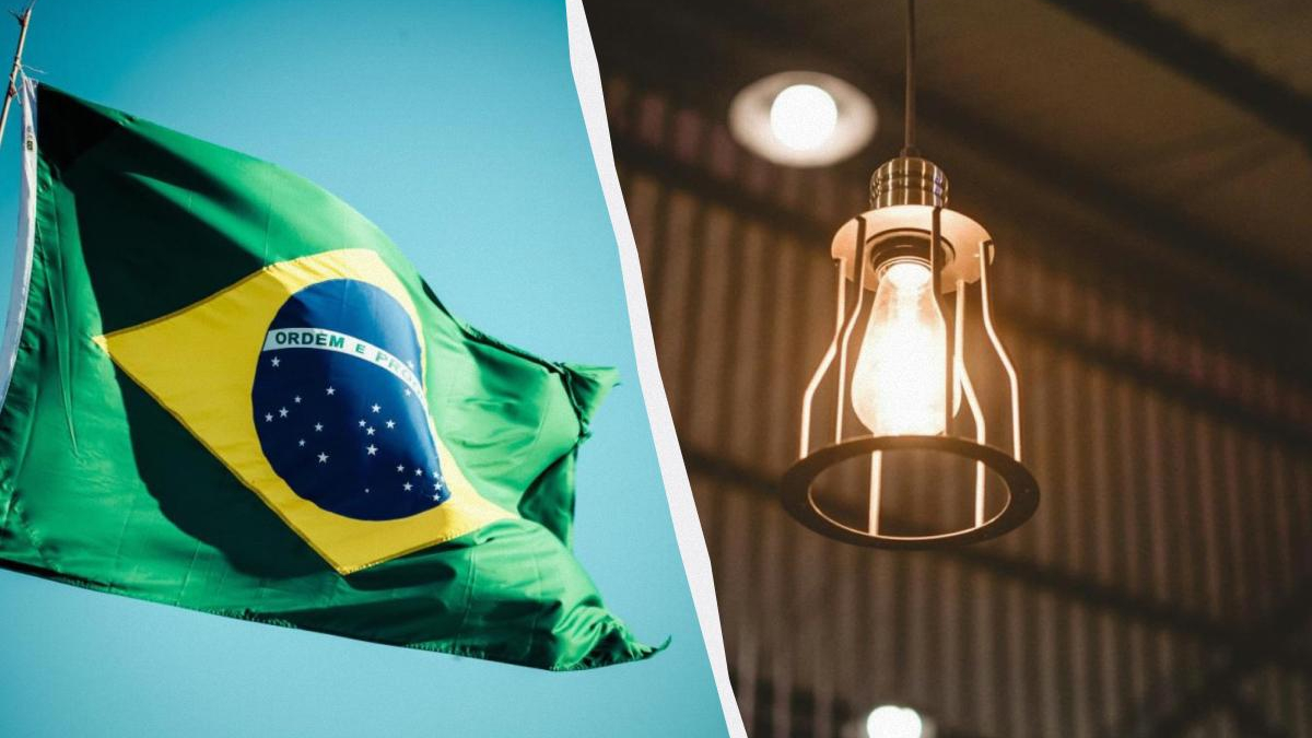 Brazil flag waving on the left with a blue sky, split by a curved divider from a warm pendant light on the right on a dark background.