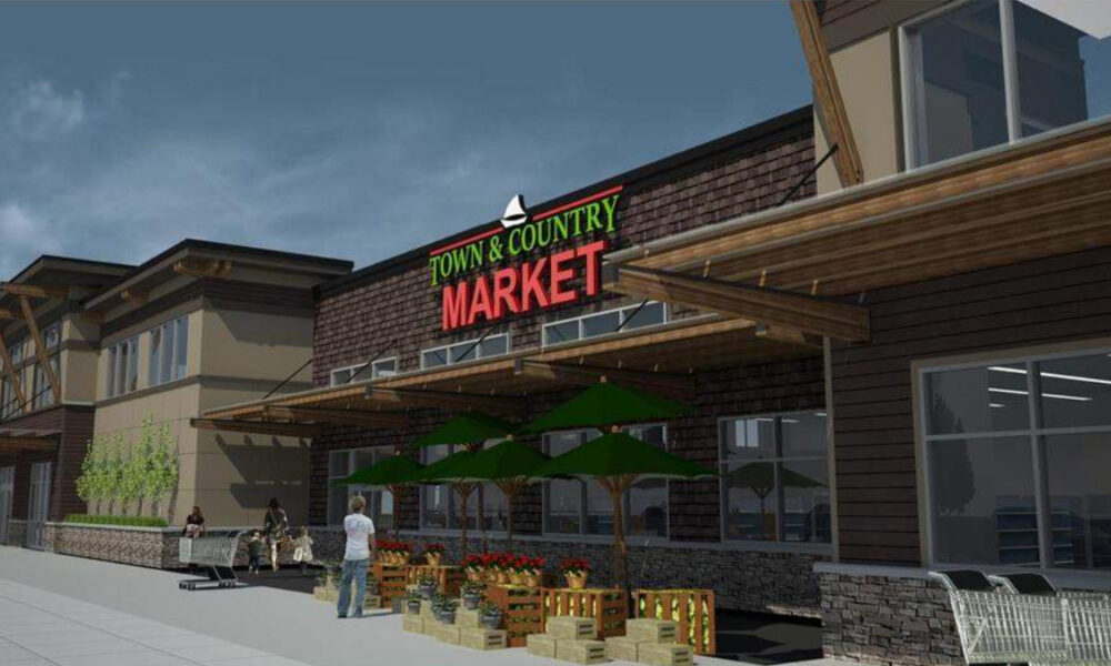 Exterior view of Town & Country Market with outdoor produce stands and shoppers nearby.