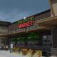 Exterior view of Town & Country Market with outdoor produce stands and shoppers nearby.