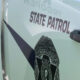 Washington State Patrol vehicle door with badge emblem and 'STATE PATROL' lettering visible