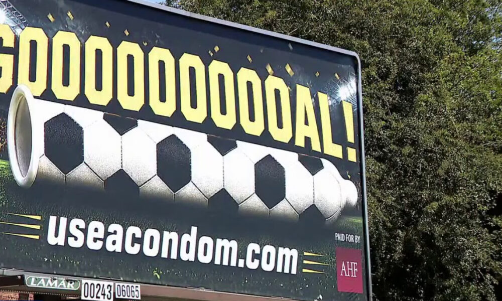 Outdoor billboard with the celebratory text 'GOOOOOOOAL!' above a stylized soccer ball and the URL 'useacondom.com' below.