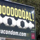 Outdoor billboard with the celebratory text 'GOOOOOOOAL!' above a stylized soccer ball and the URL 'useacondom.com' below.
