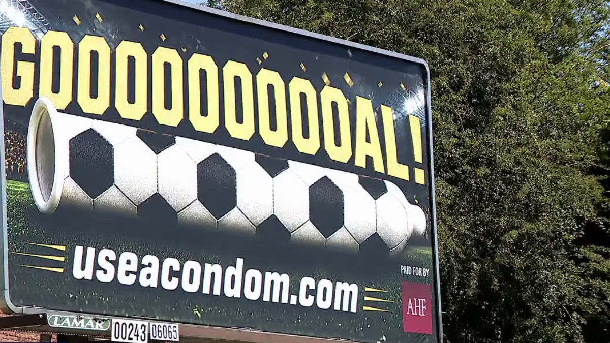 Outdoor billboard with the celebratory text 'GOOOOOOOAL!' above a stylized soccer ball and the URL 'useacondom.com' below.