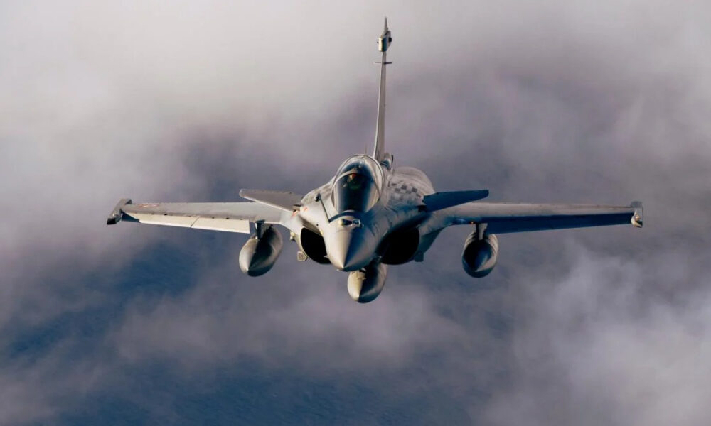 Front-on view of a fighter jet flying toward the camera through cloudy skies
