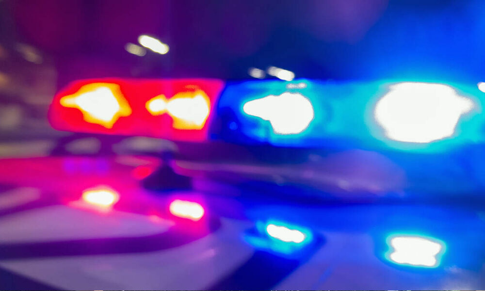 Blurry image of red and blue emergency lights flashing on a police car at night