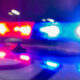 Blurry image of red and blue emergency lights flashing on a police car at night