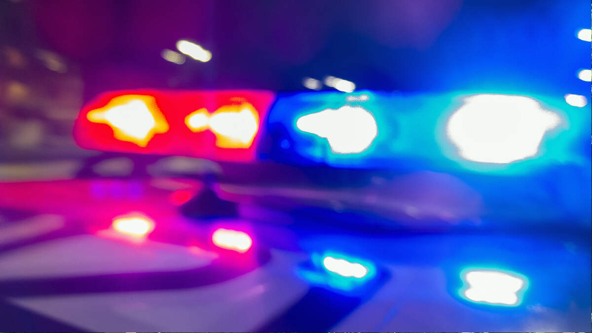 Blurry image of red and blue emergency lights flashing on a police car at night