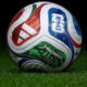 Colorful FIFA-branded soccer ball resting on green grass.