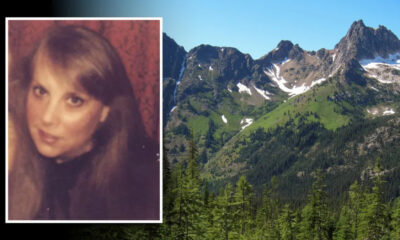 Portrait of a woman with long brown hair, framed in a white border, over a mountainous landscape background with green trees and snow-capped peaks