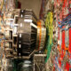 Inside a high-tech lab, a large circular magnet ring with blue and orange cables and metal support structures surrounding it.