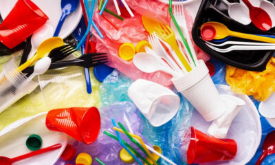 Pile of colorful plastic waste with cups, utensils, straws and bags scattered everywhere, highlighting single-use plastics.