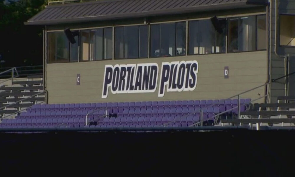 Press box at a sports stadium with a large 'Portland Pilots' sign and purple seating below.