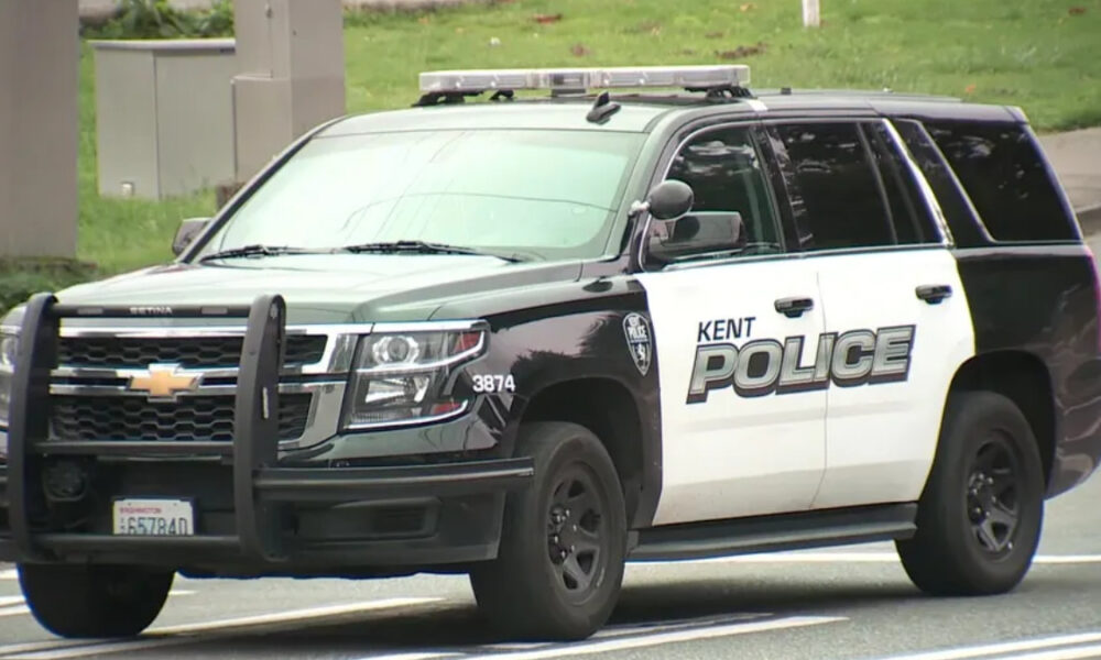 Kent Police SUV, black and white patrol vehicle with light bar on top and bold 'POLICE' lettering on the side, driving on a road