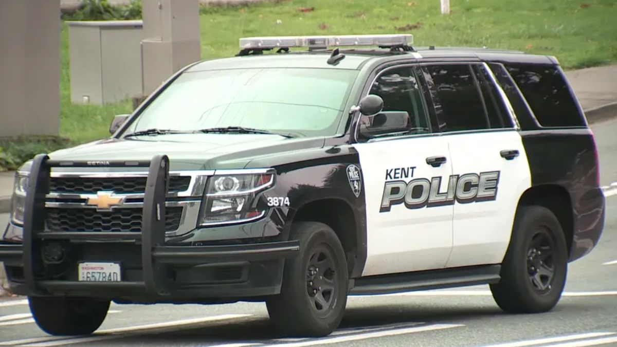 Kent Police SUV, black and white patrol vehicle with light bar on top and bold 'POLICE' lettering on the side, driving on a road
