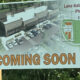 Signboard advertising Lake Kathryn Village Phase 3, showing a rendered shopping center, parking lots, and a map with a large 'COMING SOON' text at the bottom.