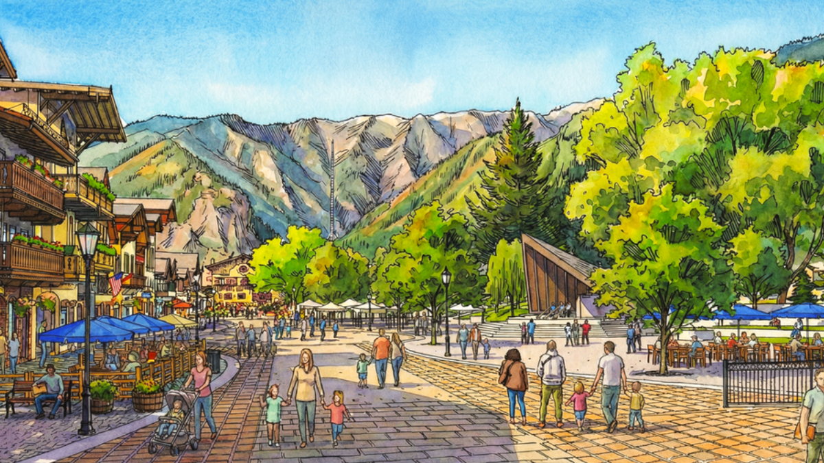Bustling mountain village square with outdoor cafes, pedestrians, and families against a backdrop of green hills and distant mountains.