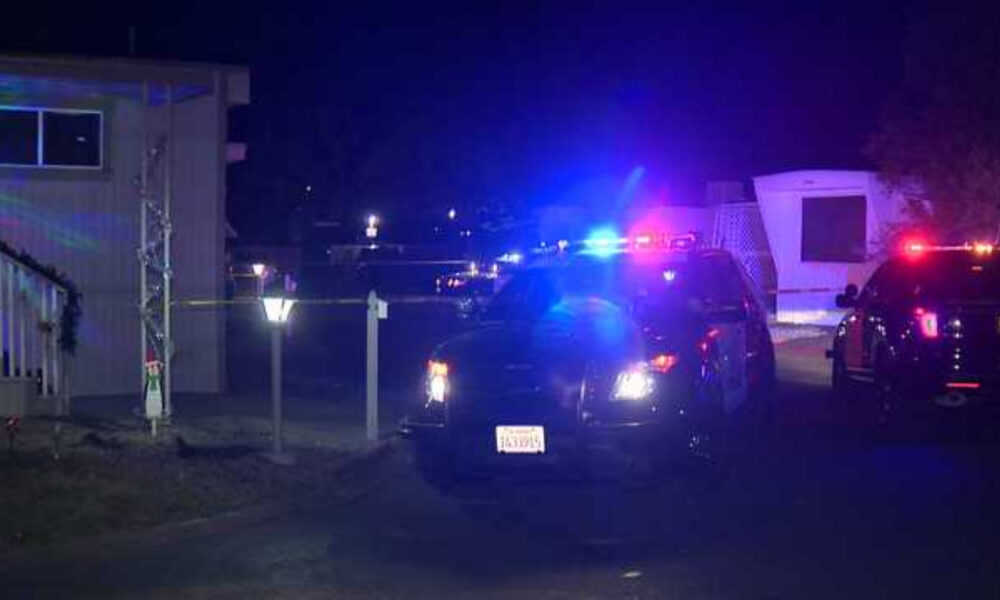 Police cars with blue and red lights at night in a residential area, yellow tape cordoning off the scene.