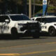 Two white sheriff patrol vehicles (SUV and sedan) parked along a street, with 'SHERIFF' markings and badge logos visible on the sides.
