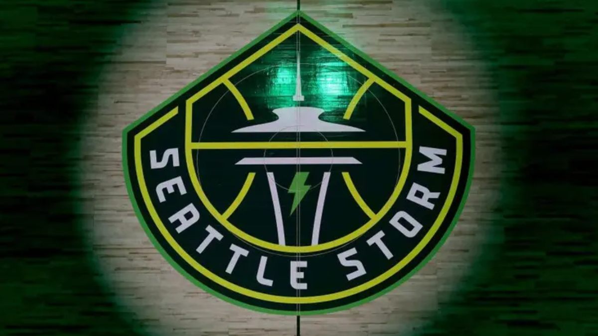 Seattle Storm team logo: a shield-shaped emblem with a green and yellow border, featuring a stylized flying saucer and a lightning bolt with 'Seattle Storm' text around the edge