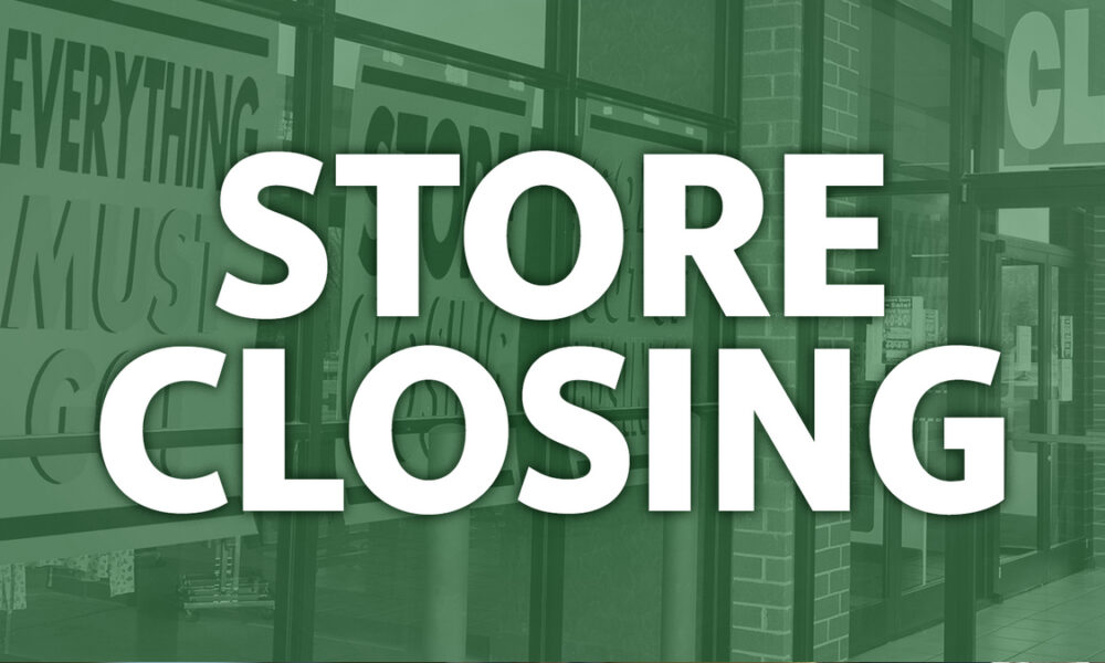 Storefront with a large white 'STORE CLOSING' message across glass doors, tinted green.