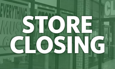 Storefront with a large white 'STORE CLOSING' message across glass doors, tinted green.