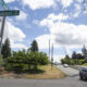 Intersection at N Madison St and N 21st St with green street signs against a blue sky, suburban road and trees nearby.