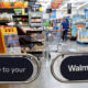 Barred entrance to a Walmart store with blue signs reading 'Welcome to your Walmart' at the checkout barrier.