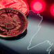 Close-up of a 2014 Russian ruble coin with an eagle, resting on a glossy surface beside a white outline map of Russia and red neon lights.