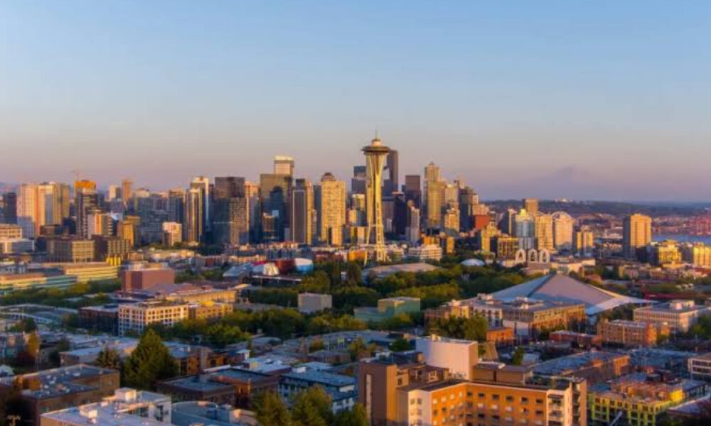 Seattle skyline at sunset with the Space Needle centerpiece and surrounding high-rises.