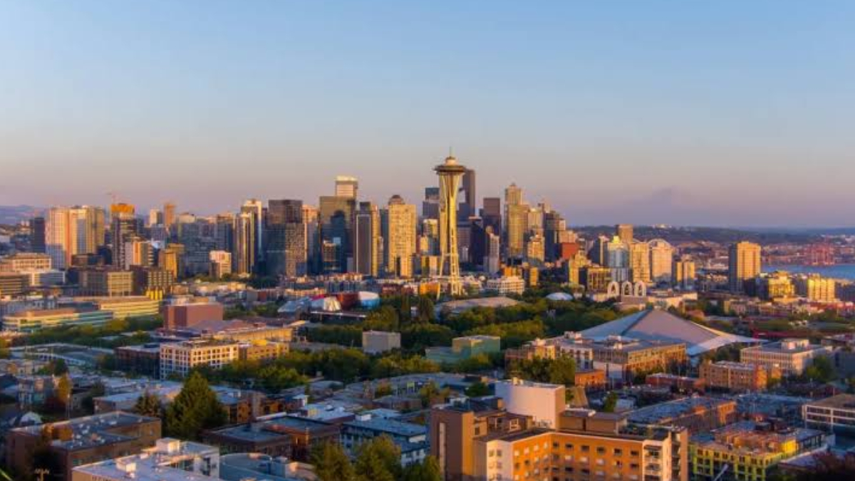 Seattle skyline at sunset with the Space Needle centerpiece and surrounding high-rises.