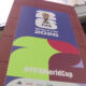 Large FIFA World Cup 2026 banner on a stadium exterior with colorful abstract shapes and the hashtag #FIFAWorldCup on it.