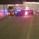Emergency vehicles with flashing red and blue lights in a dim tunnel, blocking the road at the far end.