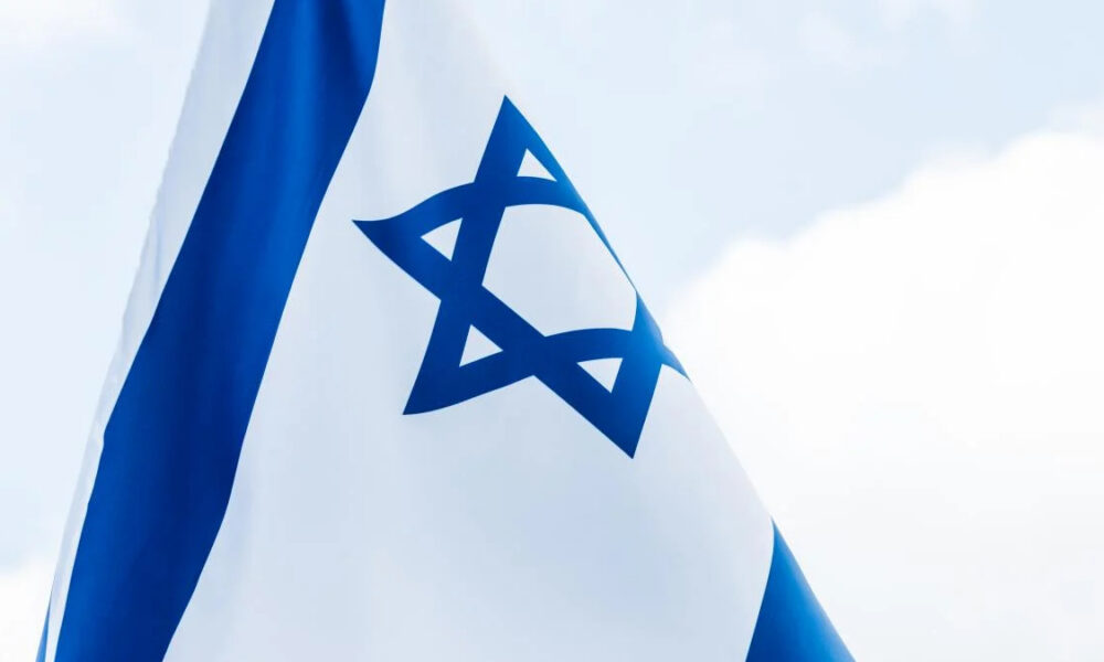 Israeli flag waving in the wind, blue stripes and a central Star of David.