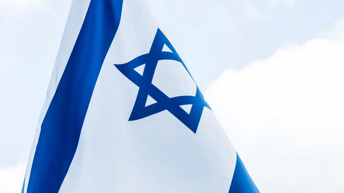 Israeli flag waving in the wind, blue stripes and a central Star of David.
